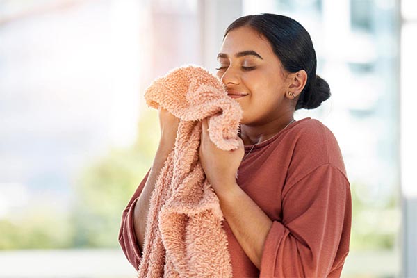 mulher cheirando uma toalha